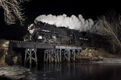 steam locomotive on a trestle at night