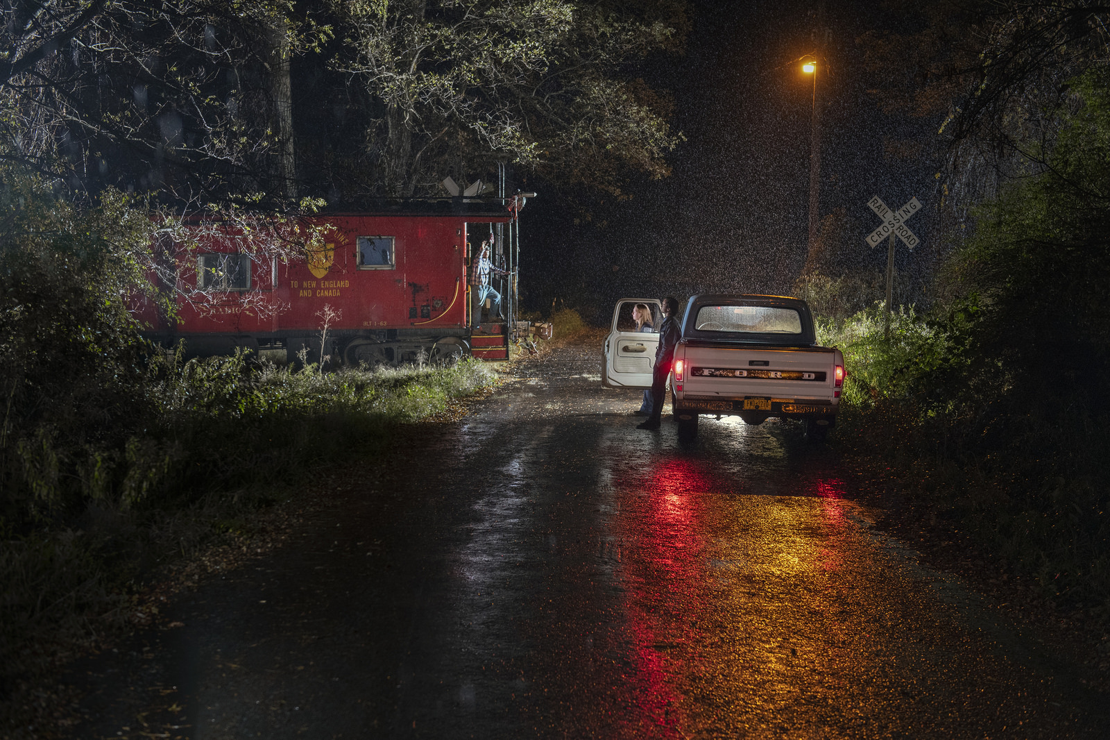 teenagers watching a passing train in the rain