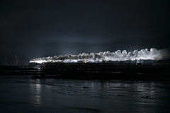 train passes over a snow covered river at night