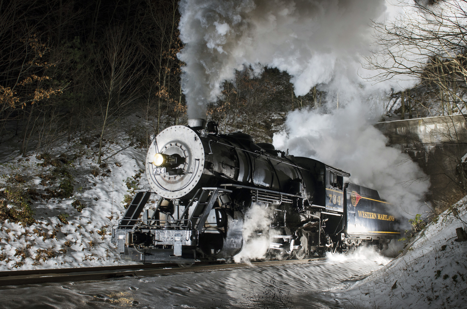 Western Maryland steam locomotive exits brush tunnel on a snowy night