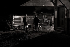 locomotive and its crew with lanterns at a depot